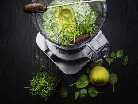 Homemade smoothie with fresh green fruits, wheat grass wheat grass, spinach, apple, banana in blenderの写真素材