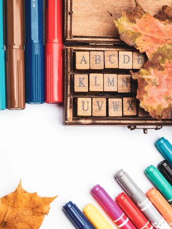 alphabet in wooden box, colorful pencils and markers, dry autumn leaves isolated on white background, Hello school concept, copy space, 1st Septemberの写真素材