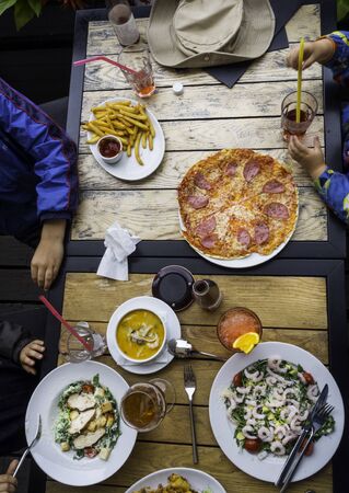 Top view family, adult and children, dinner concept, on wooden tableの写真素材