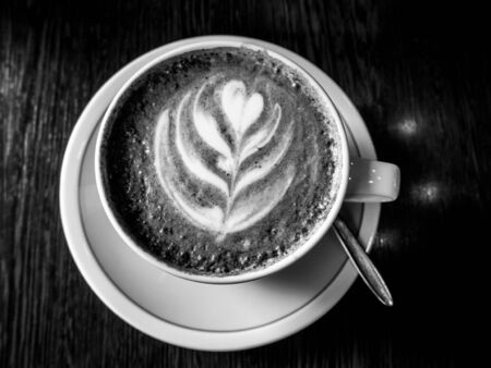 Cup of cappuccino with latte art heart shape wooden backgroundの写真素材