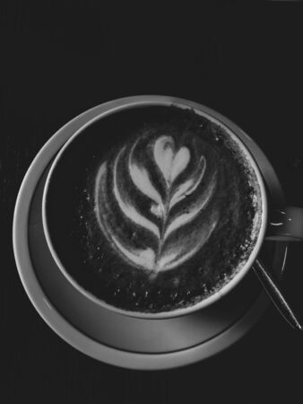 Cup of cappuccino with latte art heart shape wooden background
