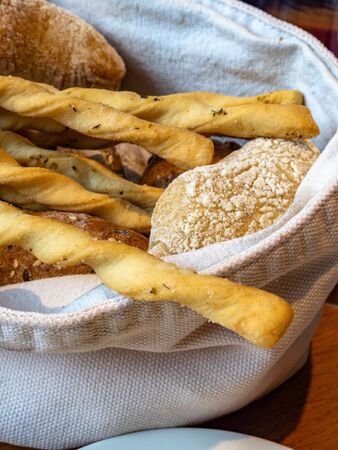 Bread and crispy breadsticks grissini in basket with butter