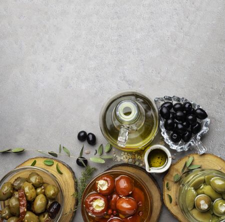 Italian food background, with bell peppers and green olives, stuffed with cheese, black olives, olive oil on wooden background.の写真素材
