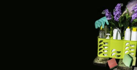 Bucket or basket with cleaning items in wooden board and black background with copy space Washing...