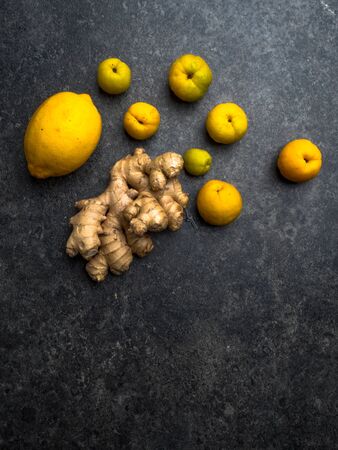 ginger root, lemon and cydonia on grey background flat lay, copy space