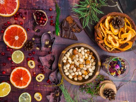 Ingredients for christmas baking spices, cookie cutters, green branch, dried apples, nuts, chocolate, fresh fruits, herbsの写真素材