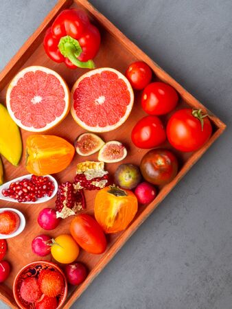 Assortment Fruits and vegetables containing lycopene. carotenoid hydrocarbon found in tomatoes, grapefruit, mango, fig, strawberries, radish, persimmon, pomegranate. Healthy vegan food background. Lycopene is a red carotenoid pigmentの写真素材