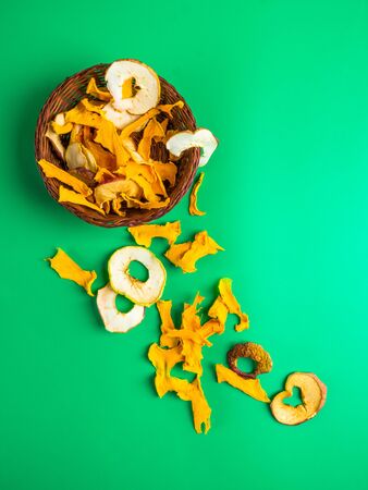 Dried apple, pumpkin slices on trendy green mint background. Top view, flat lay.の写真素材