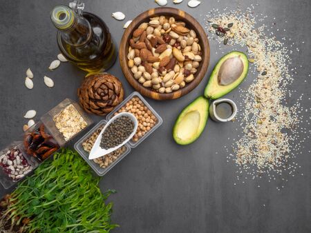 Healthy fat sources and healthy food that is useful for heart - avocado, seeds, microgreens, nuts, beans, oatmeal ang oils. Diet and healthy lifestyle concept. Vegetarian food.の写真素材