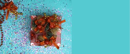 Red gift box with bow on blue bacground with conetti, Flat lay background. Festive concept....