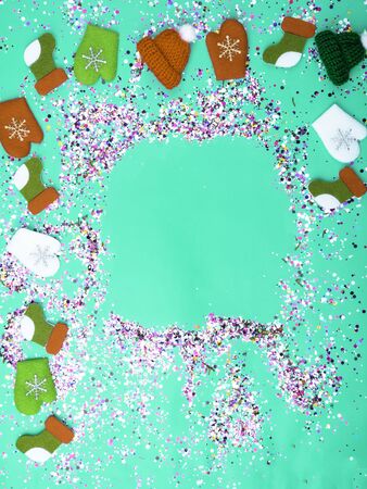 Colorful Sparkling holographic glitter confetti, toy hats, mittens, boots. Christmas Holidays abstract background, ispired by neo mint, color of 2020, Festive postcardの写真素材