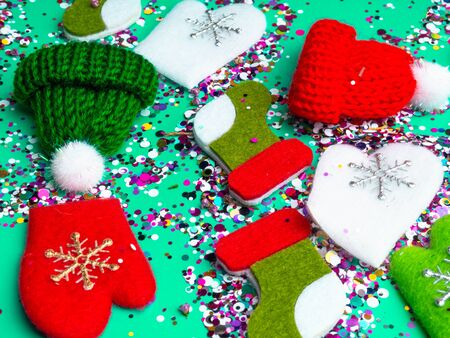 Colorful Sparkling holographic glitter confetti, toy hats, mittens, boots. Christmas Holidays abstract background, ispired by neo mint, color of 2020, Festive postcardの写真素材