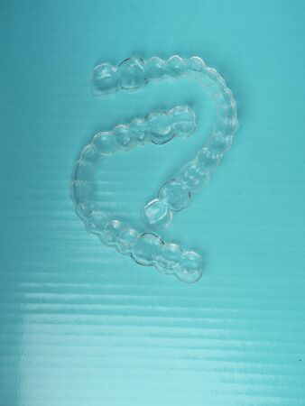 Invisible dental aligners, teeth brackets on blue background, Plastic braces dentistry retainers to...