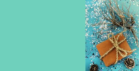 Red gift with a gold bow on a trendy background in mint green color. The concept of sales, discounts, Christmas gifts and shopping. Xmas greeting card on trendy green color background, copy spaceの写真素材