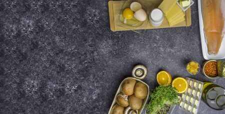 Foods containing vitamin D: fish, caviar, orange, micro greens, cheese, eggs, mushrooms, milk, butter, corn, oil, capsules. Top view. Bannerの写真素材