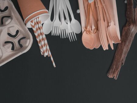 Flat lay with eco - friendly tableware, spoon, forks, knife on dark grey background, space for text,...