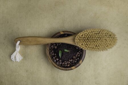 Natural organic anticellulite handmade coffee scrub, green leaves, beans in wooden bowl, massage brush, skincare and weight loss concept, flat lay. Spa Set. Top Viewの写真素材