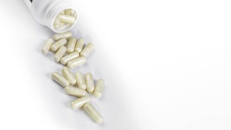 Bottle or container open with yellow pills, white background with copy space. Medicine white blankの写真素材