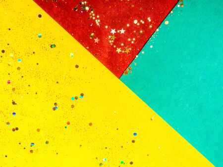 festive yellow red green cardboards background with glitters, holiday card concept, copy space