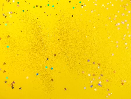 yellow background with colorful confetti glitters, festive backdrop concept, Easter, party, birthday concept with copy spaceの写真素材