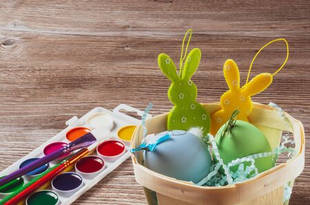 Easter basket with colorful eggs and two easter bunny, preparing for Easter conceptの写真素材