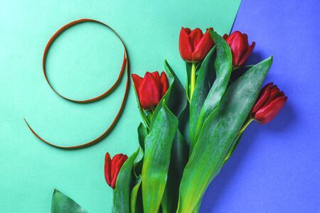 creative toned red silk ribbon shaped number nine, with tulips flower, festive postcard on blue...