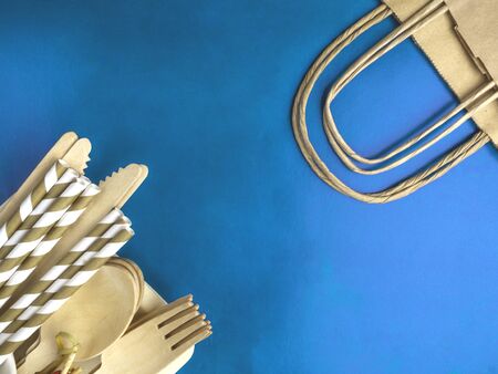 Disposable wooden cutlery on blue color background, drink tube, spoon, knife, fork cutlery, recycling, eco friendly, zero waste concept, plastic-free alternatives for environmental protectionの写真素材