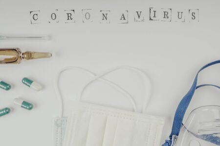 coronavirus and protection concept with ampoule, medicine, needle, injection, pills, face mask, copy space top viewの写真素材