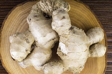 Fresh ginger root on wooden table background, antivir. Naturally elevating your energy levels, close...