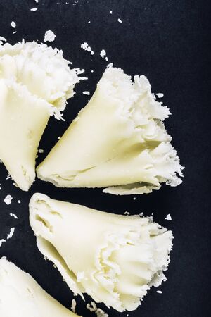 Swiss cheese Tete de Moine or monastery monk's head, scraped with a girolle special knife, rosettes on a dark slate background, copy space, selective focusの写真素材