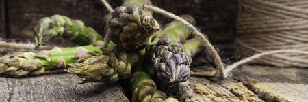 Bunch of fresh asparagus on wooden tableの写真素材