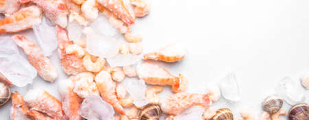 assortment of frozen seafood on ice cubes, shrimps, Babylonia areolata shellfish snails,...