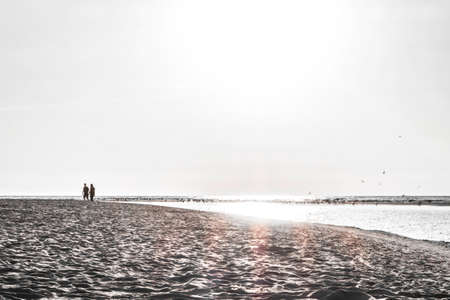 couple silhouette of two people in love at sunset, relaxed man and women walking and enjoying sunset beauty, tonedの写真素材