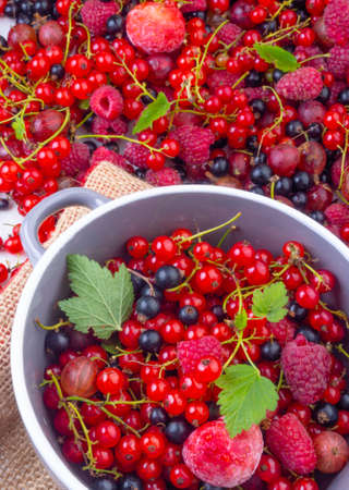 mixed fresh different berries in a bowl consisting of raw strawberries, raspberries, red and black currant, gooseberries, electve focusの写真素材