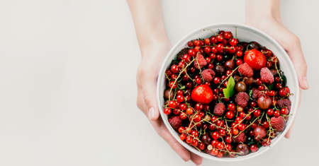 women hands holding mix of fresh summer berries, healthy eating, dieting, vegetarian food rich in vitamin and antioxidants, serlective focusの写真素材