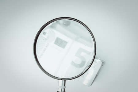 magnifying glass on 50 Euro cash banknotes. European money, fake money, currency, debt, economy and financial analysis concept.の写真素材