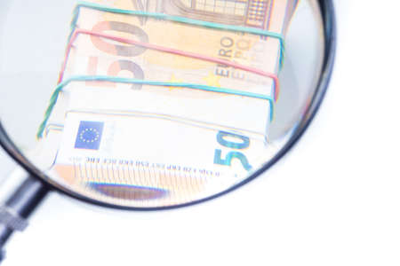 magnifying glass on 50 Euro cash banknotes. European money, fake money, currency, debt, economy and financial analysis concept.の写真素材