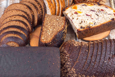 assortment of different freshly baked breads on wooden tableの写真素材