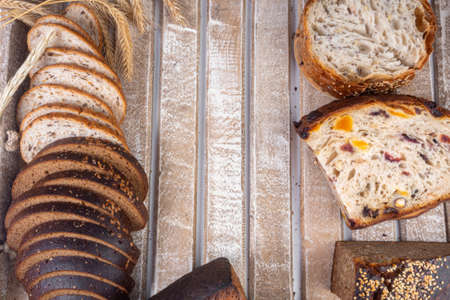 assortment of different freshly baked breads on wooden tableの写真素材