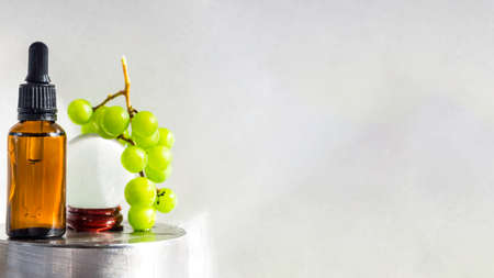 Grape seed oil in glass bottle with fresh grape, Pure essential skin care oil or serum, beauty care natural organic cosmetic. Selective focus. Bio eco products for massage, skincare and haicare. Copy spaceの写真素材