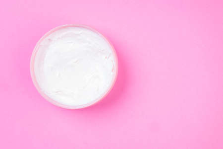 Beauty white cream in open jar for the face or body care. Top view and copy space. Moisturizing and anti aging beauty spa cosmetics. Banner with copy spaceの写真素材
