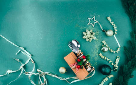 Christmas Green Festive Background with Cutlery, Holiday Setting Decorated with branches, toy, glitters and sparkles, flat lay, copy space, selective focusの写真素材