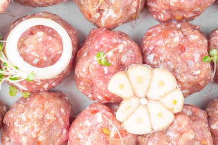 homemade raw organic mincet meat balls with onion, garlic, micro greens, uncooked, isolated on white, close up. Chinese food. Macroの写真素材