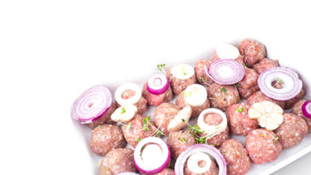 homemade raw organic mincet meat balls with onion, garlic, micro greens, uncooked, isolated on white, close up. Chinese food. Macroの写真素材