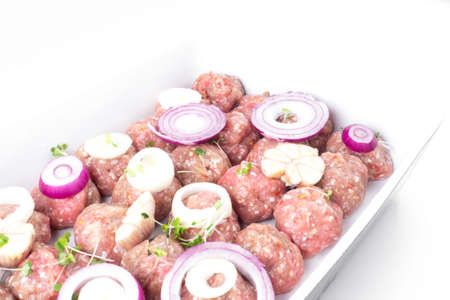 homemade raw organic mincet meat balls with onion, garlic, micro greens, uncooked, isolated on white, close up. Chinese food. Macroの写真素材