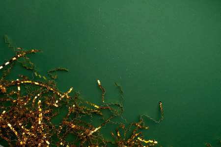 gold metallic festive copper chip paper on green background, template for your design, copy spaceの写真素材