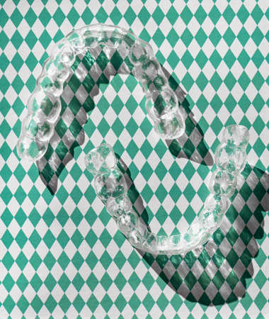 Transparent plastic dental teeth brackets tooth aligners, braces retainers to straighten teeth. Aesthetic and orthodontic modern retainers created on 3d printer. Concept of healthy and beautiful teethの写真素材