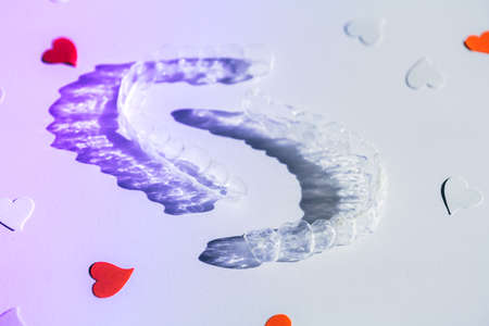 Tranparent Braces. Invisible aligners for fixing teeth after alignment with paper hearts, copy...