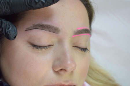 Cosmetologist who applies permanent eyebrow make-up to a young girlの写真素材