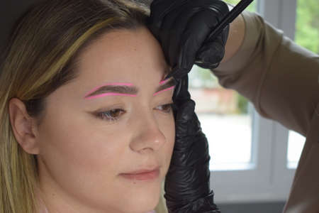 Cosmetologist who applies permanent eyebrow make-up to a young girlの写真素材